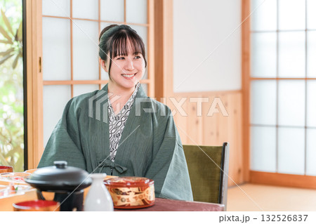 旅館で会席料理を楽しむ若いアジア人女性（部屋食・懐石料理・御膳・贅沢） 132526837
