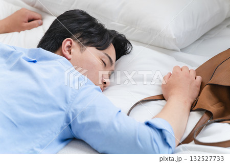 ベッドを寝落ちして朝を迎える若い男性 132527733