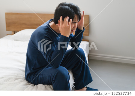 頭痛を覚える寝起きの若い男性　ライフスタイルイメージ 132527734