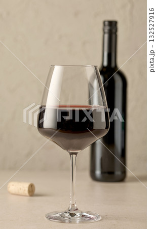 closeup of red wine glass and bottle 132527916