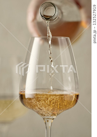 closeup of white wine pouring in glass closeup of white wine pouring in glass 132527919