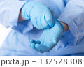 Healthcare professional putting on blue medical gloves on white background with copy space 132528308