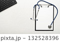 Medical background of stethoscope clipboard and computer keyboard flat lay on table with copy-space 132528396