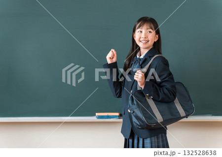 黒板の前に立ちガッツポーズをするブレザー姿の小学生,中学生,高校生の女子生徒 132528638