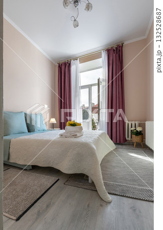 Bright Bedroom Interior with Blue Pillows and Balcony View 132528687