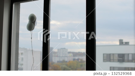 Washing of panoramic windows. Window cleaning robot. The assistant window cleaner robot moves on soft pads on the glass. Polishing of the glass surface. Washing of panoramic windows. Window cleaning robot. The assistant window cleaner robot moves on soft pads on the glass. Polishing of the glass surface. 132529368