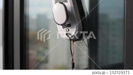 Close-up of automatic window cleaner robot. Working on residential window. Simplicity and convenience of window cleaning. 132529371