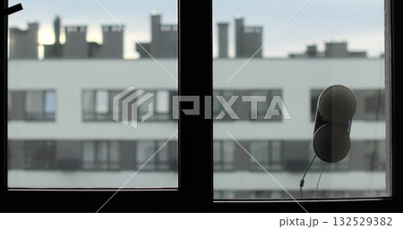 Window cleaning robot in action on glass, modern smart home appliance for automated cleaning. Simplicity and convenience of window cleaning. 132529382
