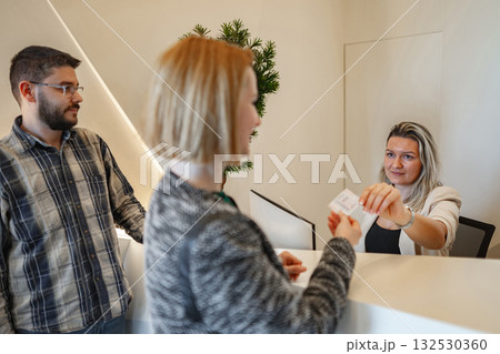 Woman Handing Man Piece of Paper Woman Handing Man Piece of Paper 132530360