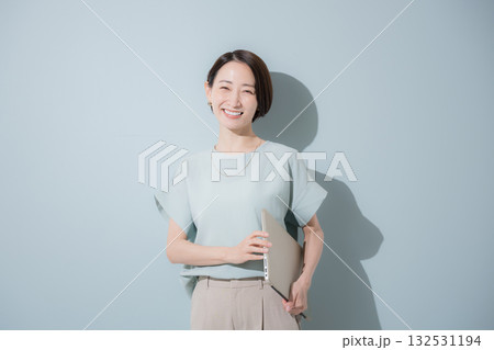 綺麗なミントグリーン背景のビジネス女性イメージ パソコンを持つ 綺麗なミントグリーン背景のビジネス女性イメージ パソコンを持つ 132531194