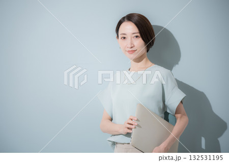 綺麗なミントグリーン背景のビジネス女性イメージ パソコンを持つ 綺麗なミントグリーン背景のビジネス女性イメージ パソコンを持つ 132531195