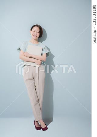 綺麗なミントグリーン背景のビジネス女性イメージ 笑顔でパソコンを抱える 綺麗なミントグリーン背景のビジネス女性イメージ 笑顔でパソコンを抱える 132531199