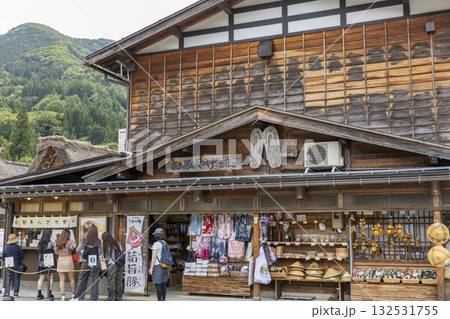 白川郷の伝統的なお土産屋と藁草履・民芸品を楽しむ観光客の風景 白川郷の伝統的なお土産屋と藁草履・民芸品を楽しむ観光客の風景 132531755