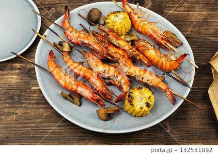 Shrimp langoustines skewers on wooden surface. Shrimp langoustines skewers on wooden surface. 132531892