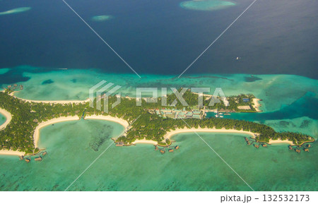 Amazing atoll and island in Maldives from aerial view. Tranquil tropical landscape and seascape with palm trees on white sandy beach, peaceful nature in luxury resort island. Summer holiday mood 132532173