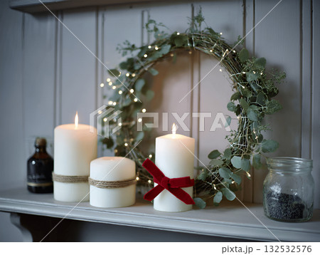 lit candles with green wreath and garland create festive atmosphere of coziness and warmth- lit candles with green wreath and garland create festive atmosphere of coziness and warmth- 132532576