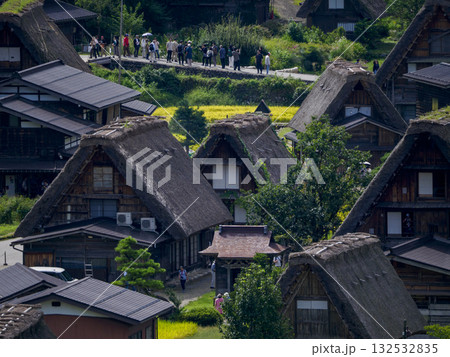 白川郷の合掌造り集落の俯瞰風景、観光客が行き交う歴史的な茅葺き屋根の家々 白川郷の合掌造り集落の俯瞰風景、観光客が行き交う歴史的な茅葺き屋根の家々 132532835