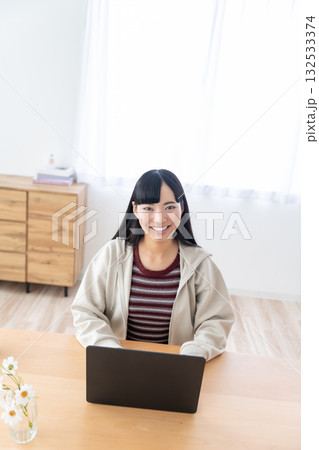 自宅でパソコンを操作する女子大生 132533374