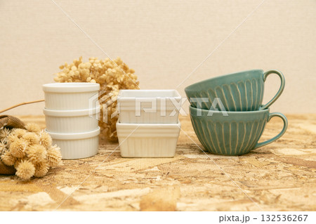 洋風の食器のテーブルフォト　ココットとスープカップがコンパネの上に並べられている 132536267