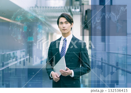 DX デジタルイメージ　パソコンを持って立つスーツの若い男性　撮影協力:スカパー東京メディアセンター 132536415