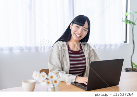自宅でパソコンを操作する若い女性 132537264