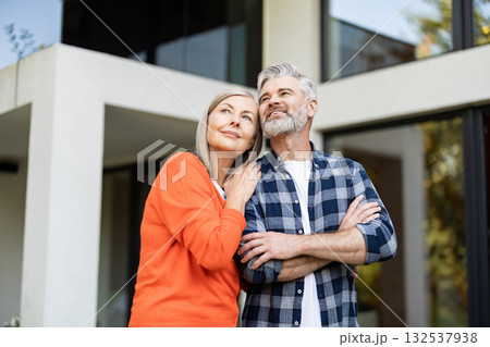 Senior man and woman together near their house looking happy and contented Senior man and woman together near their house looking happy and contented 132537938