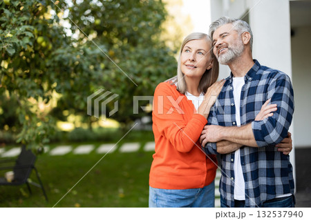 Senior man and woman together near their house looking happy and contented Senior man and woman together near their house looking happy and contented 132537940