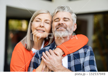 Senior man and woman together near their house looking happy and contented Senior man and woman together near their house looking happy and contented 132537949