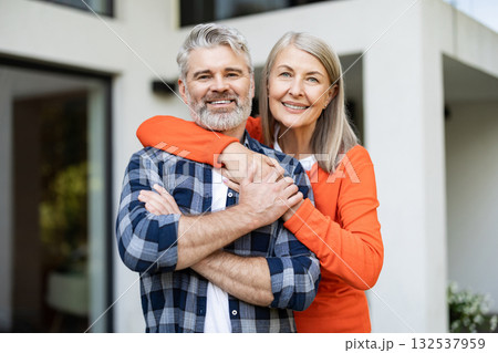 Cute woman in orange shirt hugging her husband and smiling nicely 132537959