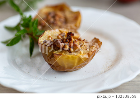 Warm homemade baked apples topped with walnuts and cinnamon Warm homemade baked apples topped with walnuts and cinnamon 132538359