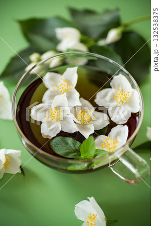 Glass teapot with jasmine and green tea isolated Glass teapot with jasmine and green tea isolated 132538375
