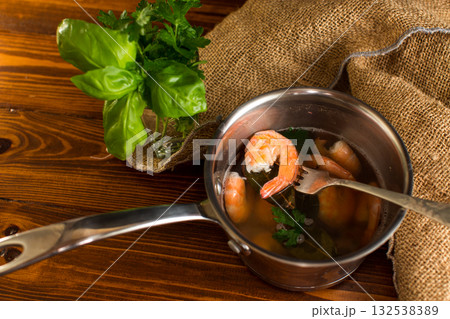 Ready to eat red shrimps in a pan, on a wooden table 132538389