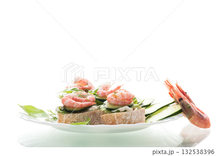 Small canapes with shrimps, salad and cucumbers on a white background 132538396