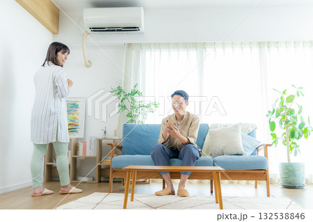 リビングでスマホを見る夫婦 リビングでスマホを見る夫婦 132538846