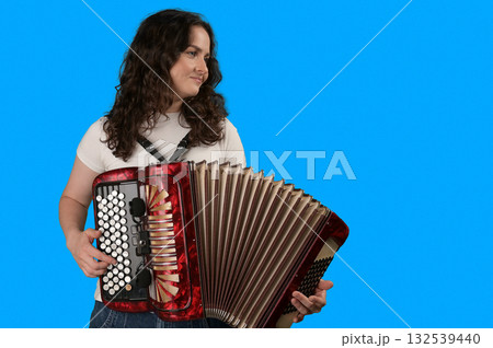 Young woman with a button accordion. Adult woman plays the button accordion 132539440