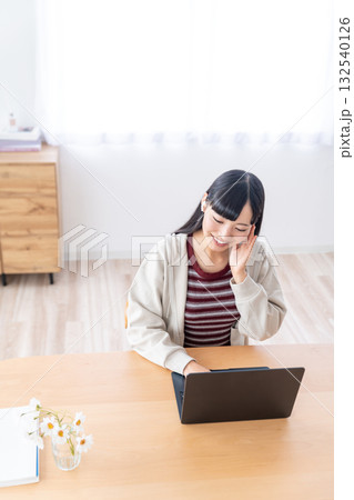 自宅でパソコンを操作する若い女性 自宅でパソコンを操作する若い女性 132540126