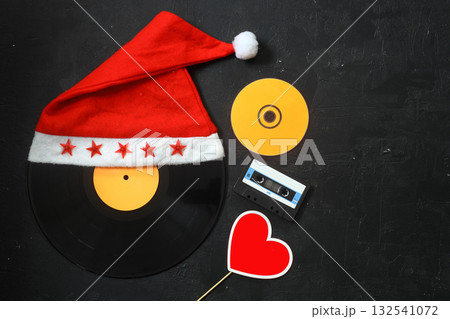 Happy New Years 2022. Christmas background with santa claus hats, vinyl LP Record , heart shape and cassette. Top view 132541072