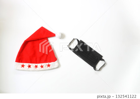Funny christmas greeting card with santa hat and medical face mask. Flat lay with copy space Funny christmas greeting card with santa hat and medical face mask. Flat lay with copy space 132541122