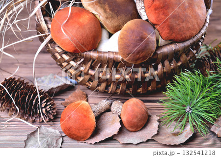 Edible mushrooms, porcini and boletus in a wicker basket on a natural wooden background Edible mushrooms, porcini and boletus in a wicker basket on a natural wooden background 132541218
