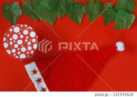 Christmas sparkling Santa Claus hat on red background. And gift box 132541626