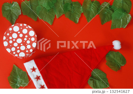 Christmas sparkling Santa Claus hat on red background. And gift box 132541627