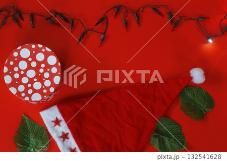 Christmas sparkling Santa Claus hat on red background. And gift box Christmas sparkling Santa Claus hat on red background. And gift box 132541628