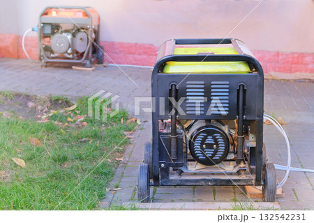 Energy independence. Business use mobile generator. Power supply generator placed on street sidewalk. Outdoor diesel power generator in autumn season. 132542231
