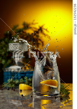 Slice of lemon fall in glass with cocktail, creating beautiful splashes. 132542236