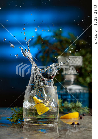 Slice of lemon fall in glass with cocktail, creating beautiful splashes. Slice of lemon fall in glass with cocktail, creating beautiful splashes. 132542243