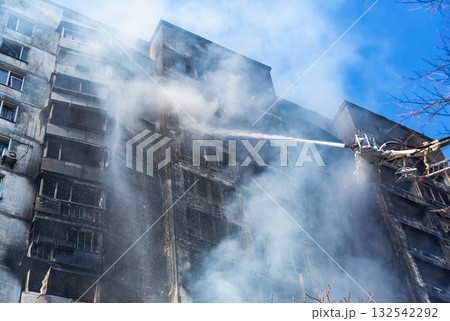 Extinguishing a fire in a multi-storey building after shelling by the Russian army Extinguishing a fire in a multi-storey building after shelling by the Russian army 132542292