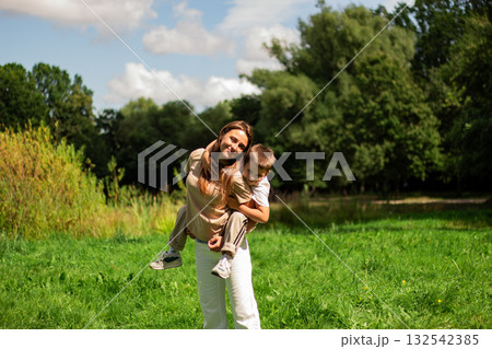 Carefree childhood moment. Preschool boy and mom twirl. Ideal for parenting and happiness themes. 132542385