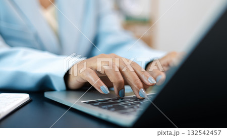 Businesswoman Typing on Laptop Computer in Office Workspace 132542457