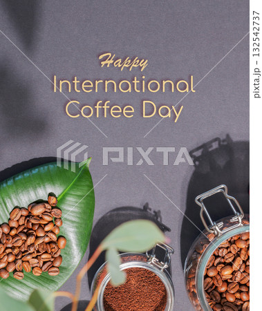 International coffee day card with organic roasted coffee beans on a green leaves and coffee powder in a glass jar on a black background with congratulations text International coffee day card with organic roasted coffee beans on a green leaves and coffee powder in a glass jar on a black background with congratulations text 132542737