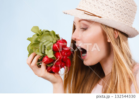 Happy woman biting radish Happy woman biting radish 132544330